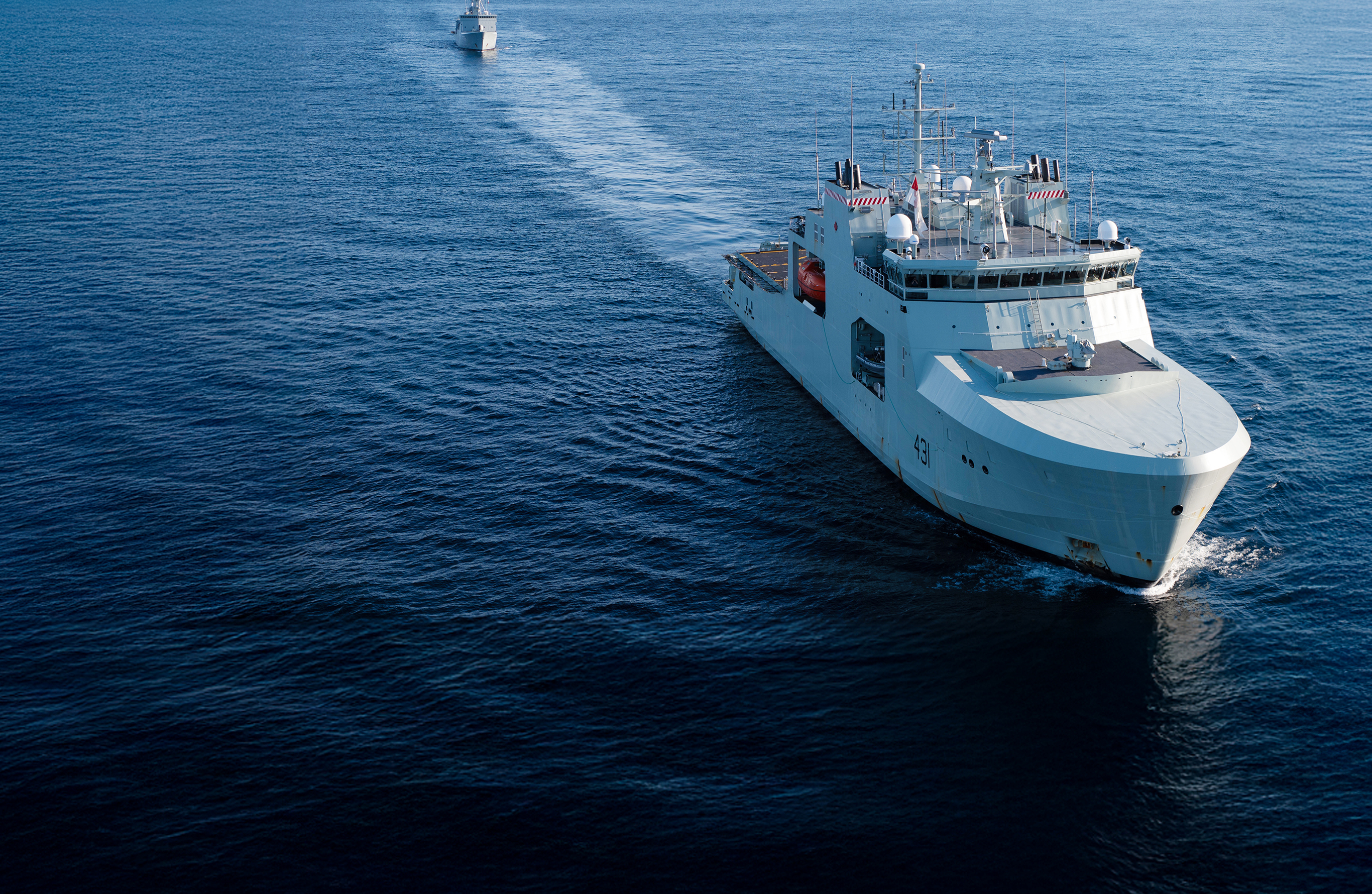 Header Image. Military Vessel sailing through calm blue waters